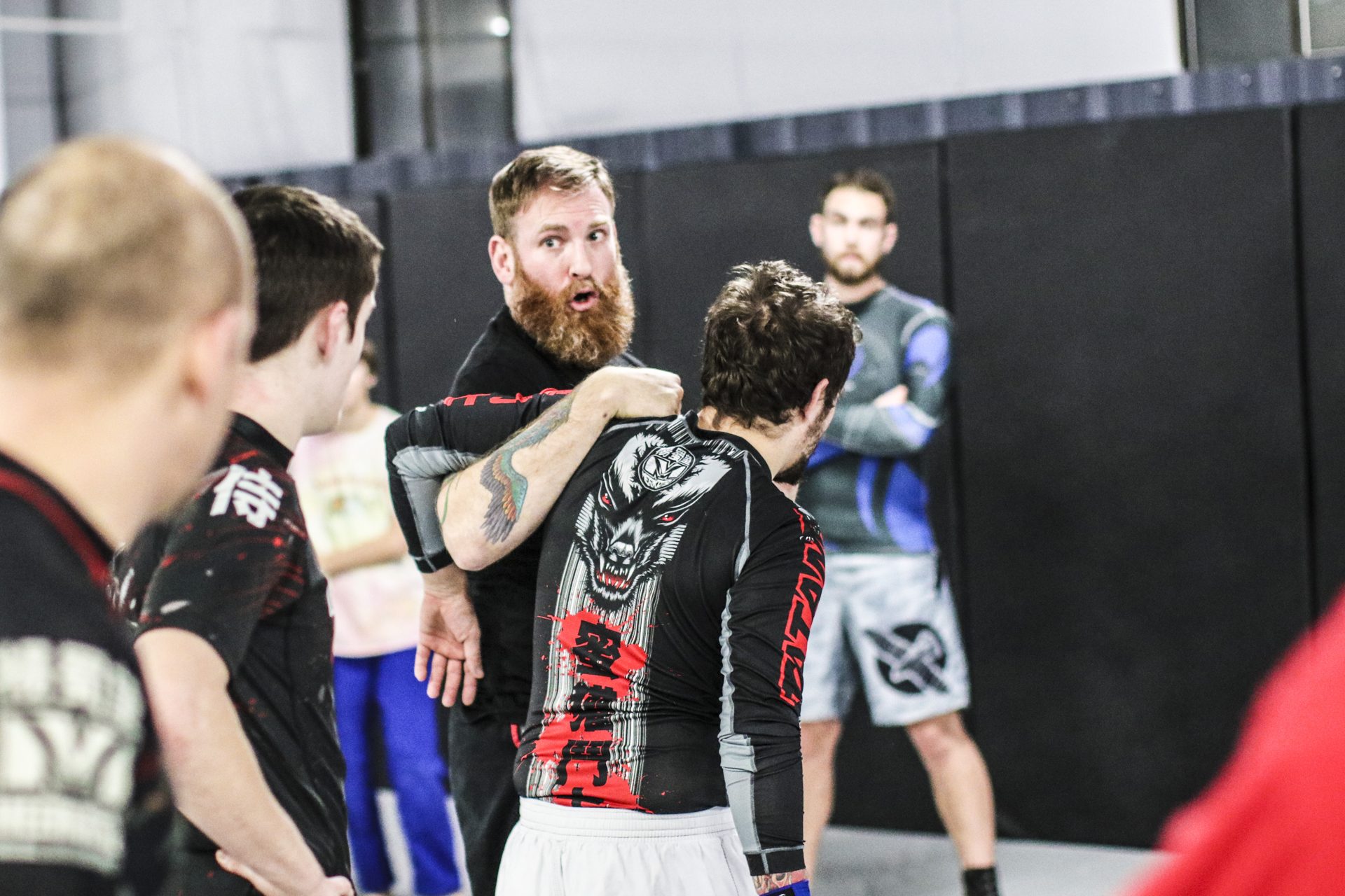 Matt Bryers coaching a student through a standing position during class