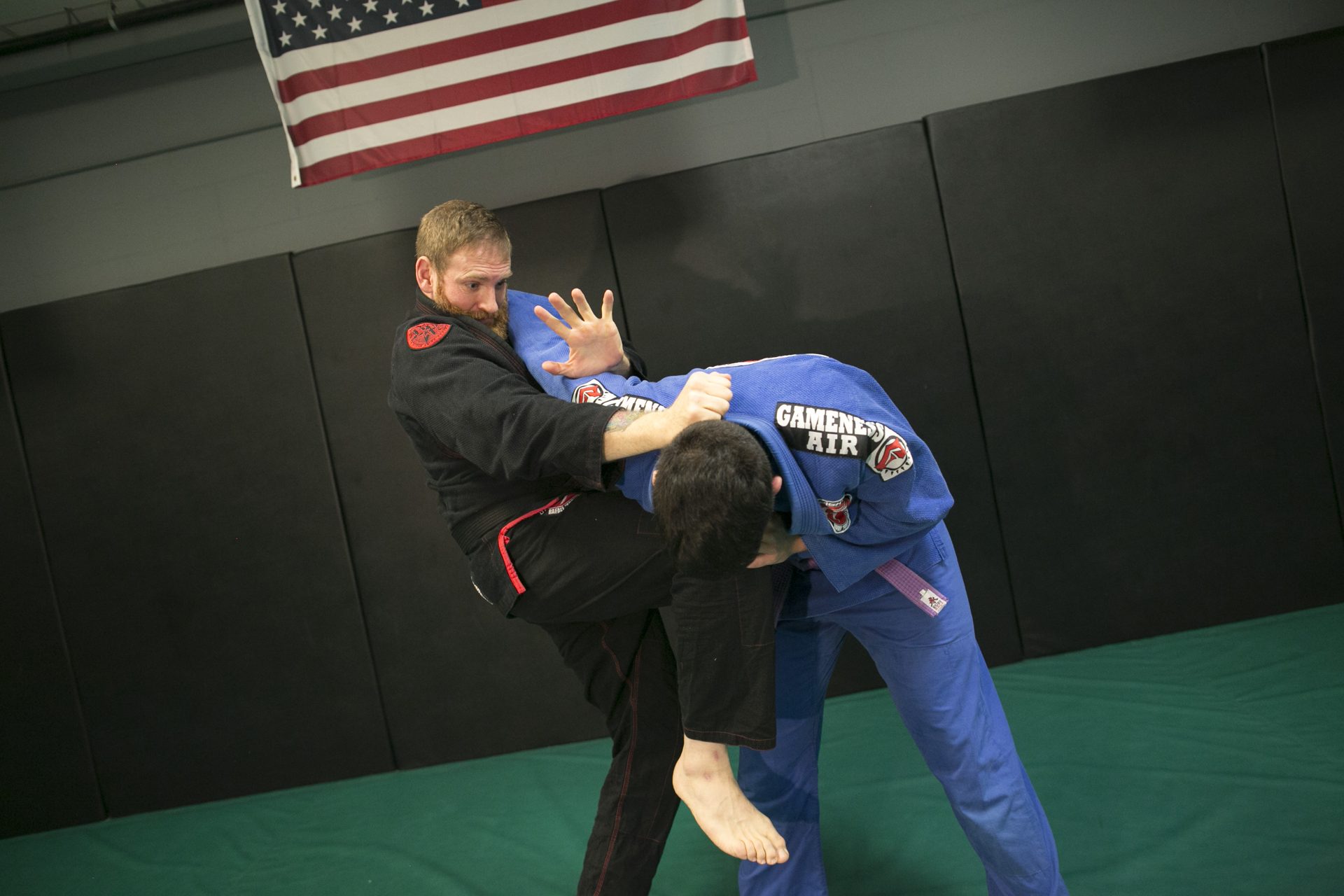 Matt Bryers in a black gi controlling a training partner's head during gi training