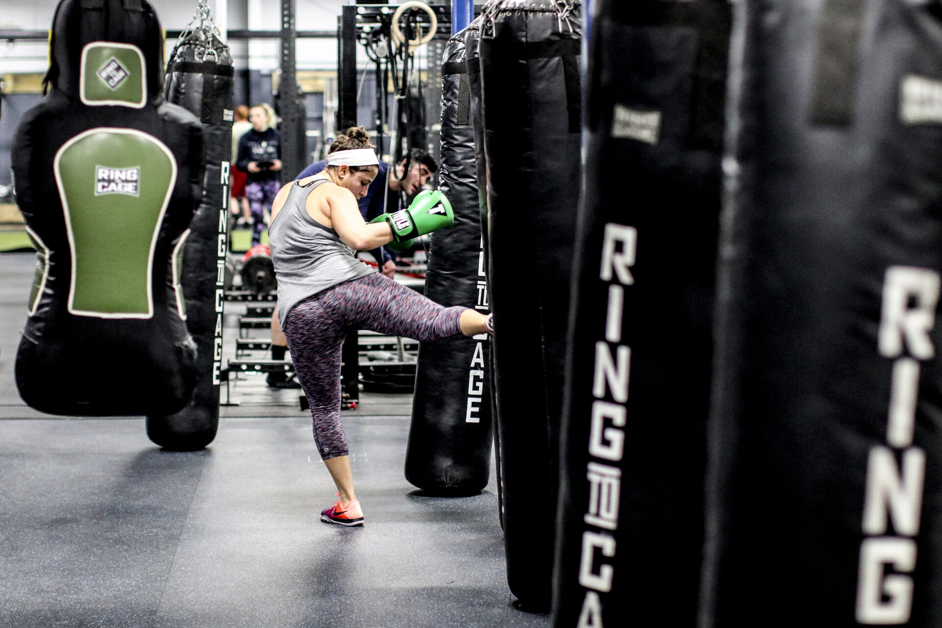 A round kick landing on a heavy bag